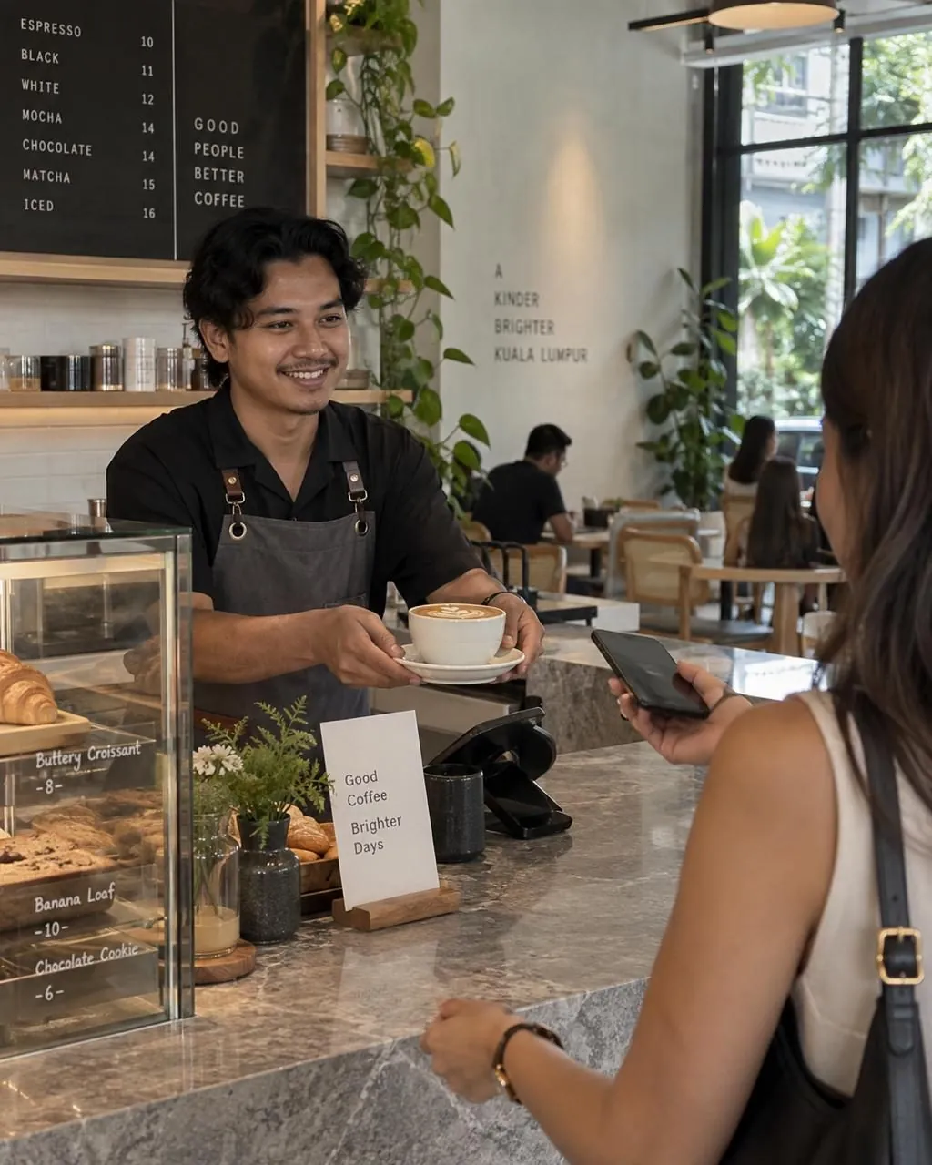 A customer paying by QR code at a Malaysian cafe counter